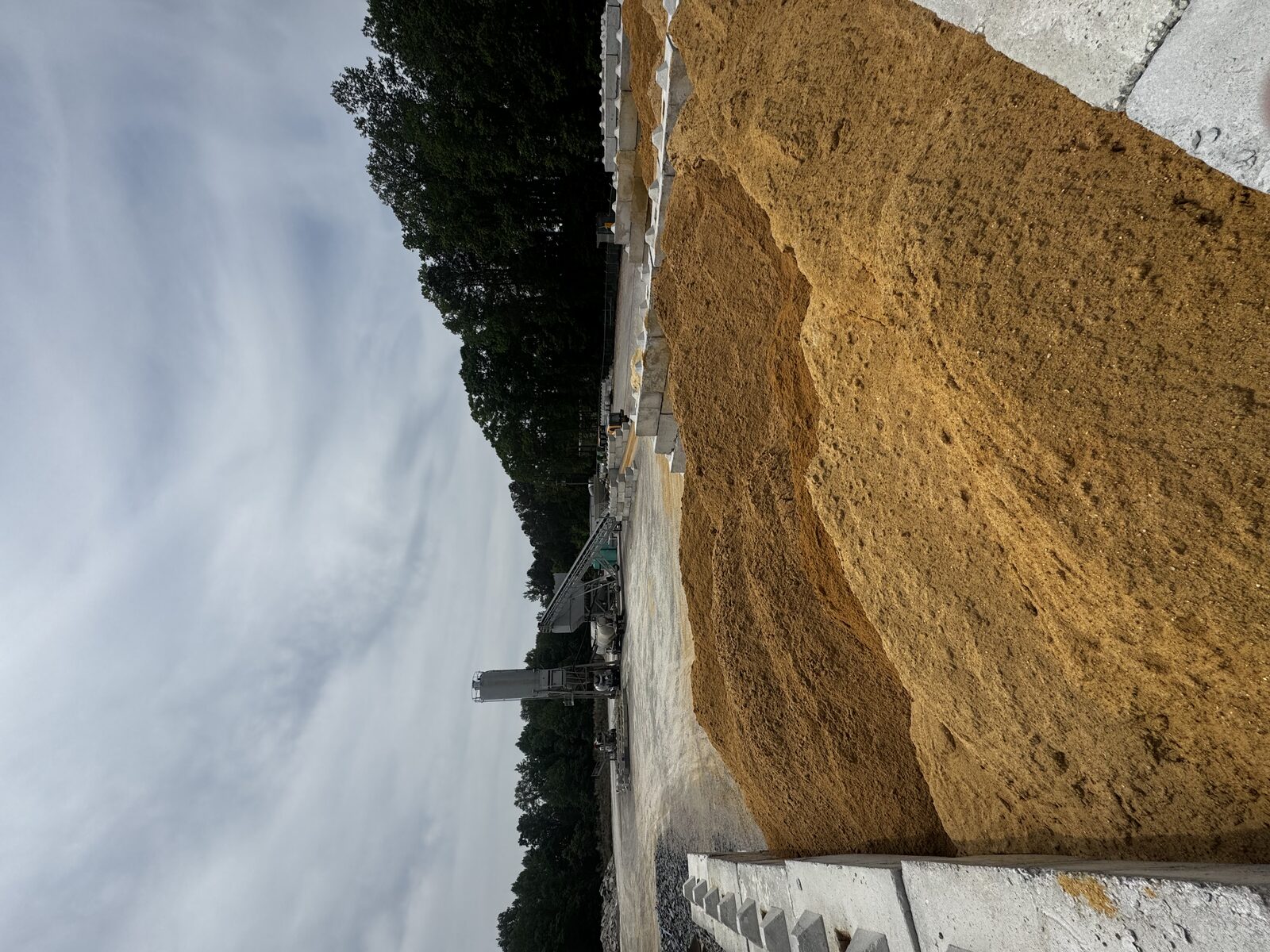 SRM mixer truck loading concrete at the batch plant with silos