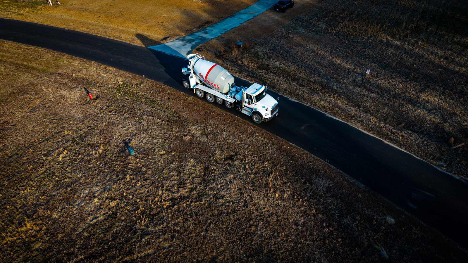Aerial view of SRM mixer truck on rural road delivering concrete